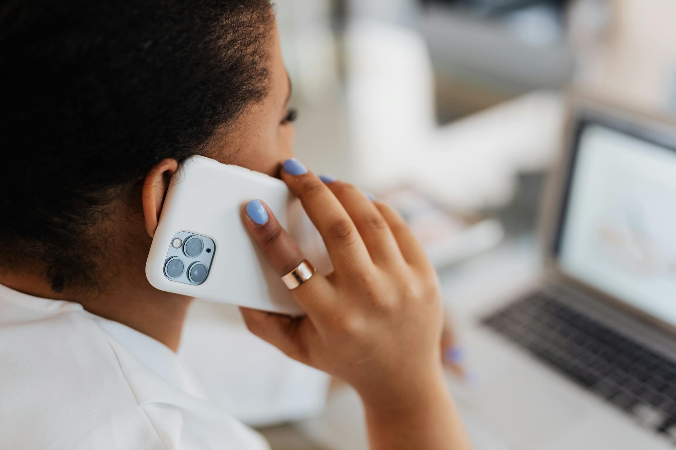 Close-up of a person using a smartphone while working indoors, showcasing technology and connection.